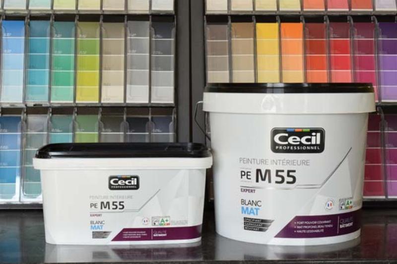 Application soignée de peinture 5 litres avec pinceau et rouleau sur un mur intérieur