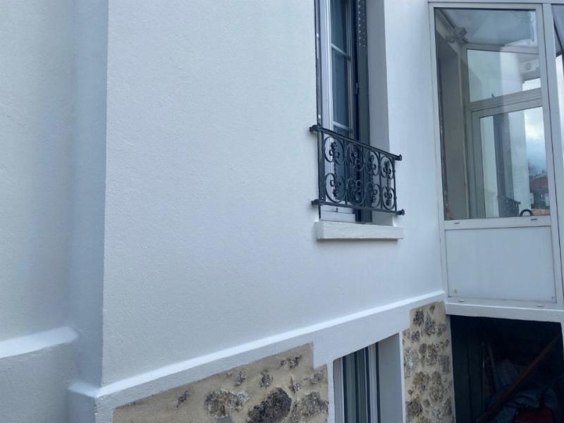 Peinture isolante extérieure appliquée sur une façade de maison traditionnelle française, améliorant son esthétique et son isolation thermique.