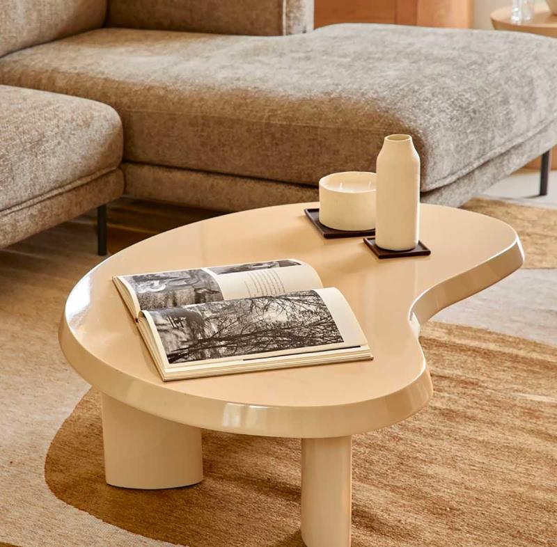 Mur d'accent orange vif dans un salon moderne aux meubles neutres, créant un point focal chaleureux et invitant.