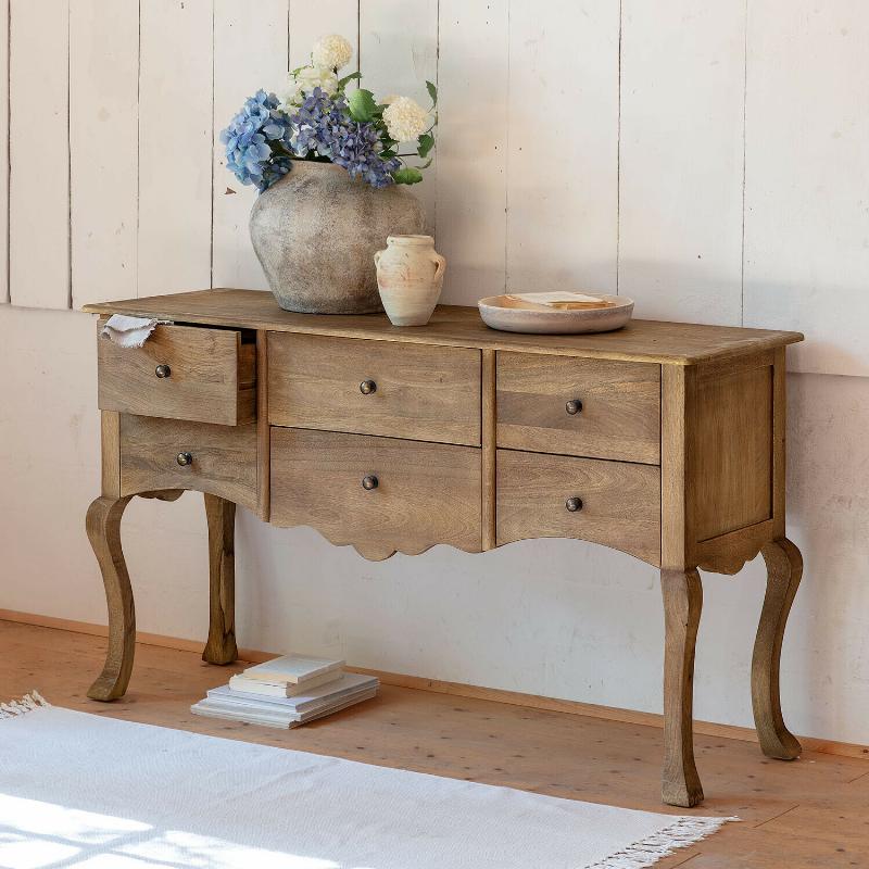 Porte intérieure peinte en bleu pastel avec poignée en laiton vieilli, dans un salon lumineux de style français.