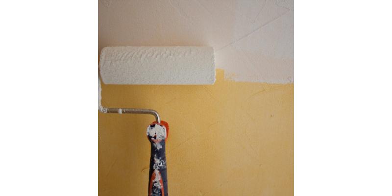 Application soignée d'une sous-couche pour carrelage au rouleau sur un mur préparé