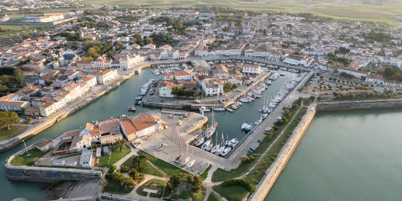 Peinture d'une venelle pittoresque d'un village français, capturant la lumière douce et les détails architecturaux anciens.